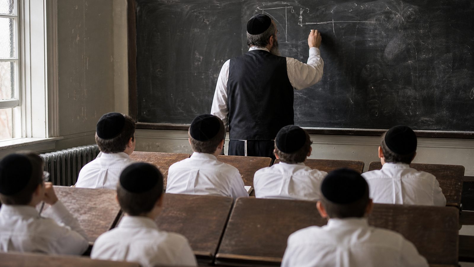 A rebbi at the blackboard, seen from behind